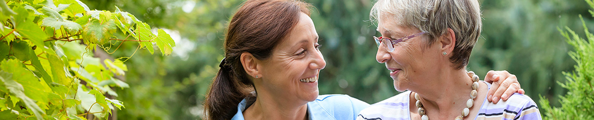 Senior woman and caregiver smiling together
