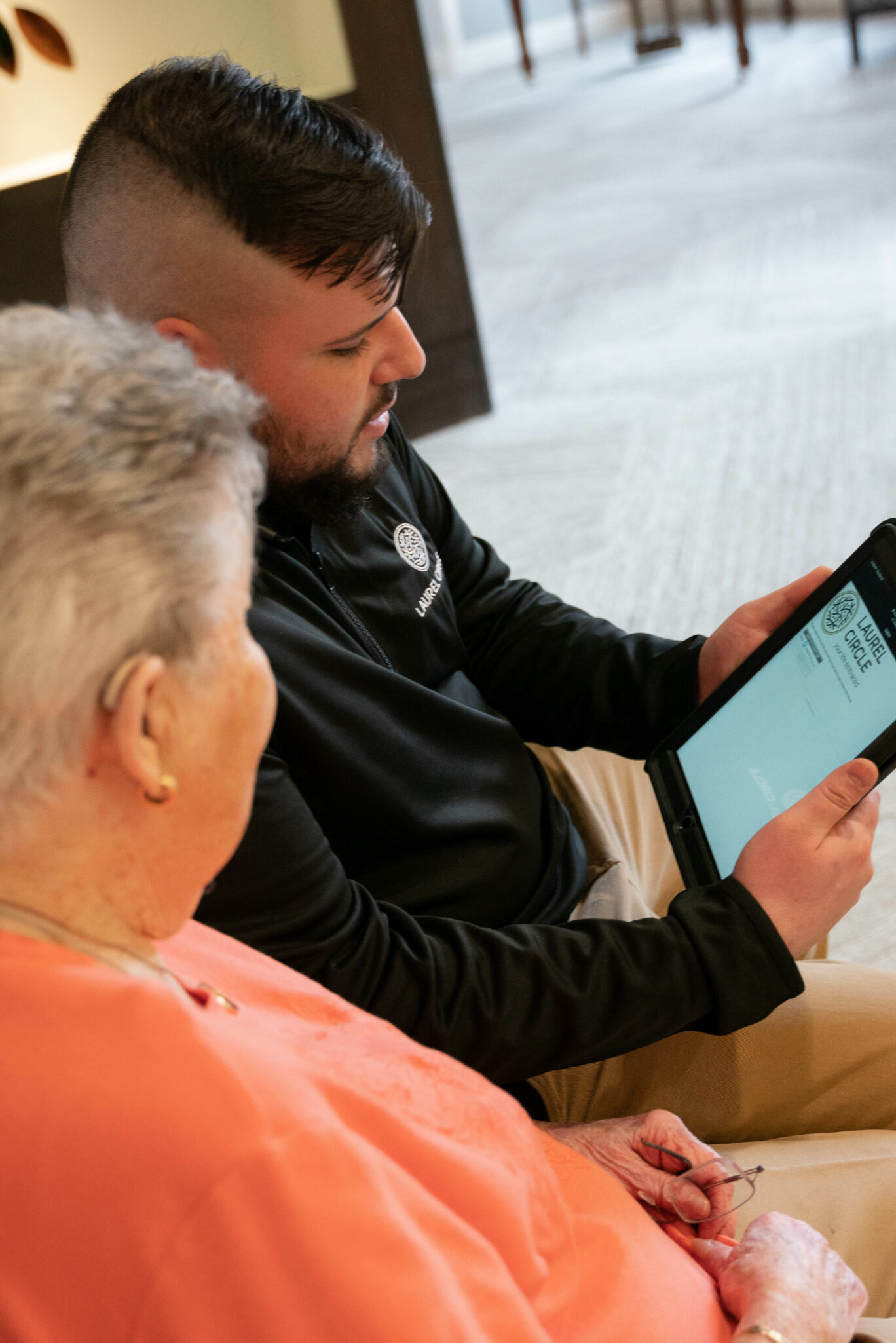 Caregiver helping senior living resident with technology