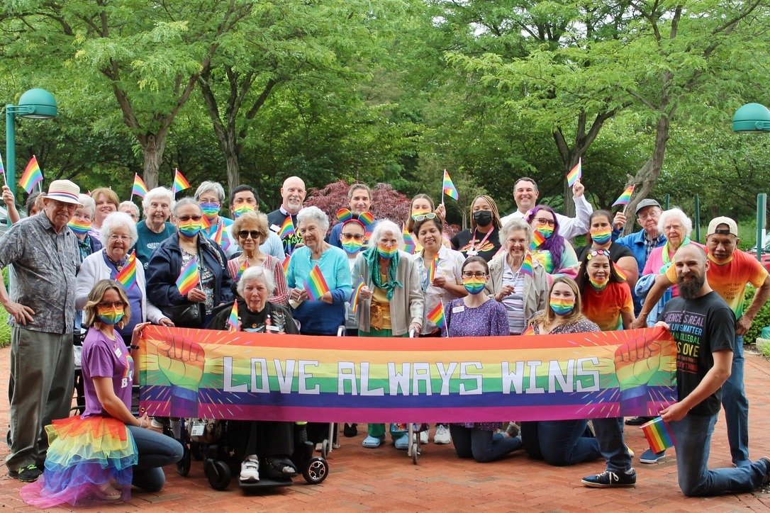 Pride walk participants holding up banner