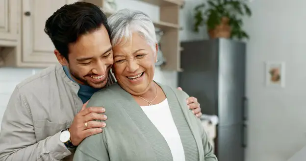 a son hugging his senior mother