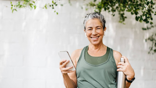 senior lady smiling after exercise with phone